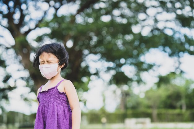 Portrait of girl standing against tree