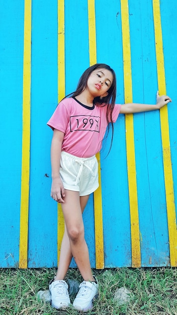 Photo portrait of girl standing against wall