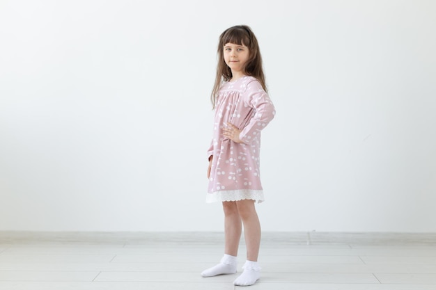 Photo portrait of a girl standing against wall