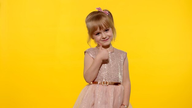 Portrait of a girl standing against yellow background