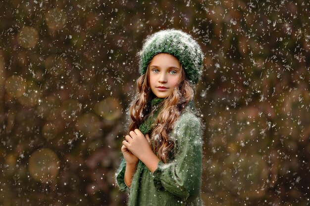 Foto ritratto di una ragazza in piedi durante la nevicata