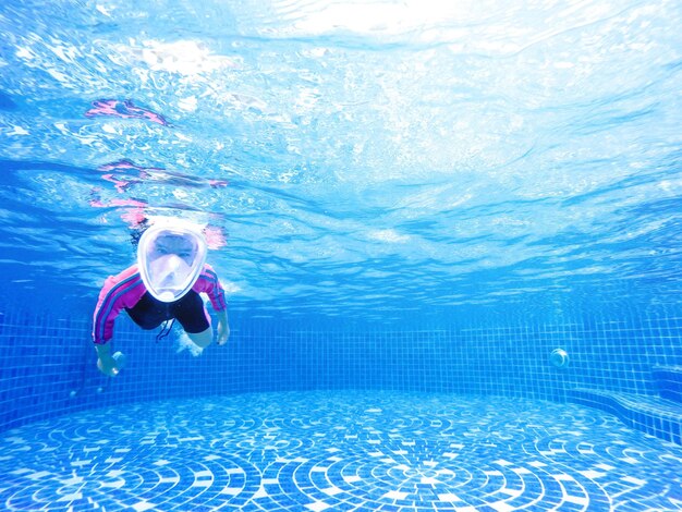 Portrait of girl swimming underwater in pool