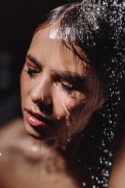 Portrait of a girl taking a shower. Creative makeup theme. Non-washable make-up.