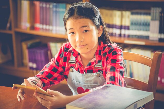 Photo portrait of girl using digital tablet while sitting on table