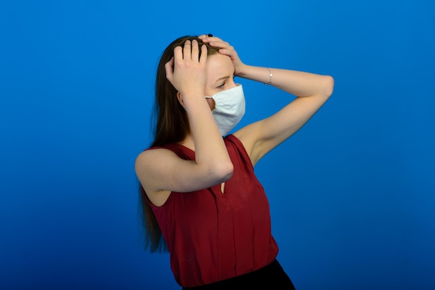 Portrait of a girl wearing a face mask on a blue background