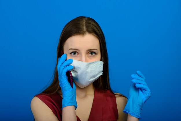 Portrait of a girl wearing a face mask on a blue background