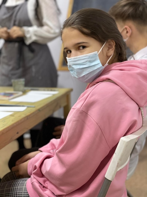 Foto ritratto di una ragazza che indossa una maschera sulla sedia