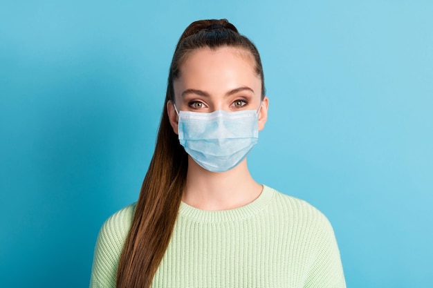 Portrait of girl wearing mask green pullover isolated over bright vivid shine vibrant blue color background