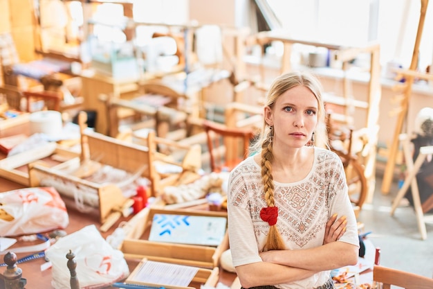 Portrait of a girl weaver in the workshop