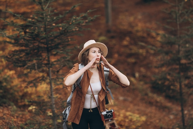 Portrait of a girl who got lost in the woods. Beautiful girl in a hat in the autumn forest