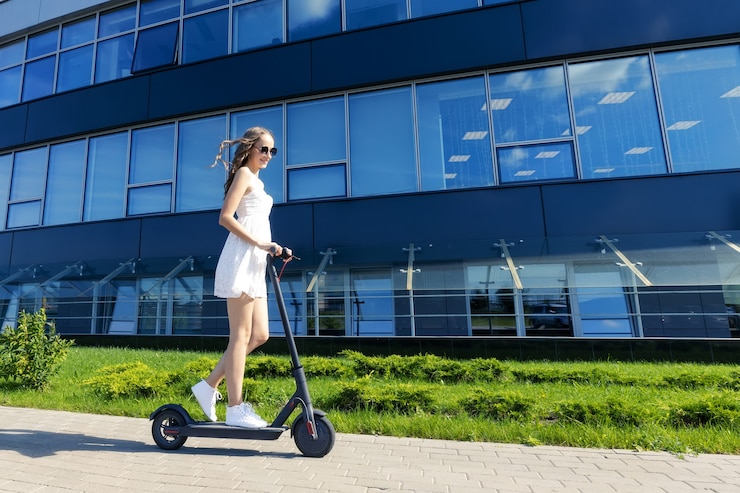 Photo portrait of a girl who rides an electric scooter in the city