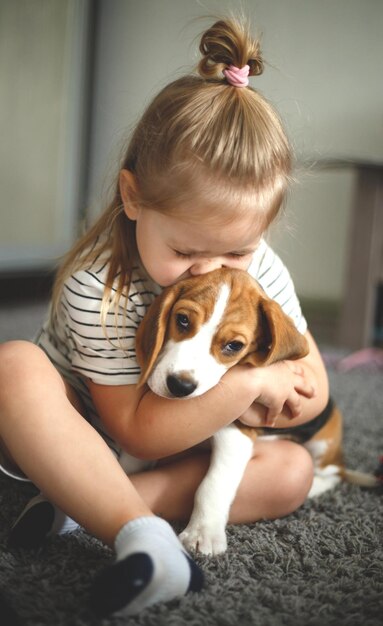 Photo portrait of girl with dog at home