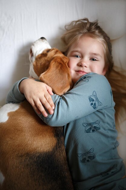 Foto ritratto di una ragazza con un cane sdraiato sul letto