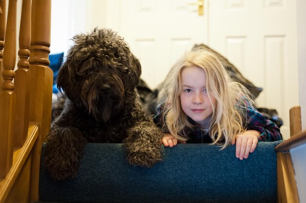 Photo portrait of girl with dog lying at home