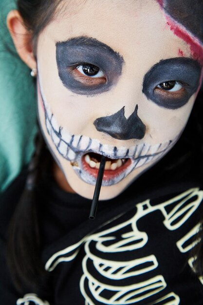 Foto ritratto di una ragazza con la vernice sul viso durante halloween