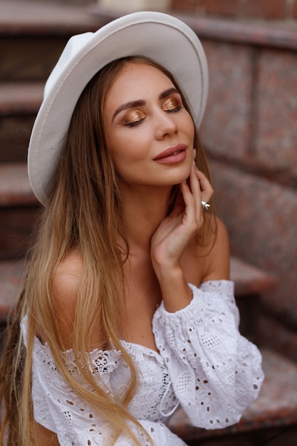 Portrait of a girl with a glitter make-up and a white hat