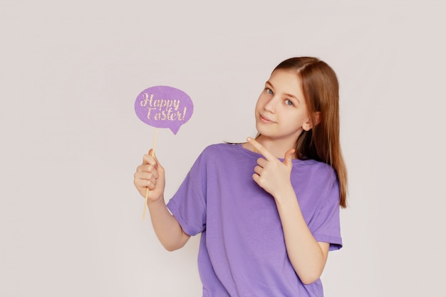 Portrait of a girl with a happy Easter sign in her hands