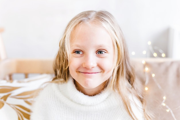 Portrait of a girl with long blonde hair the house decorated for Christmas