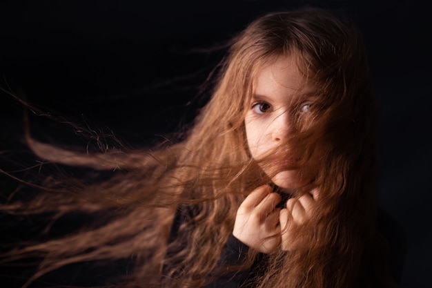 Foto ritratto di una ragazza con i capelli lunghi su sfondo nero