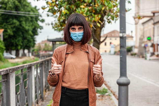 Foto ritratto di una ragazza con mascherina medica all'aperto durante la quarantena covid in italia