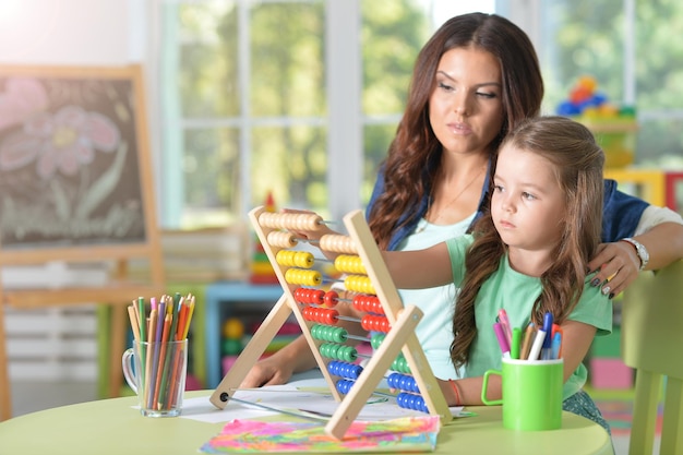 Portrait of girl with mother using abacus