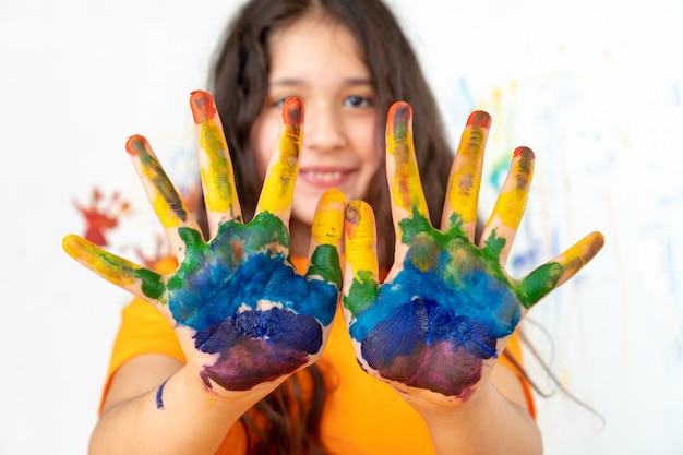 Photo portrait of a girl with multi-colored palms. back to school.