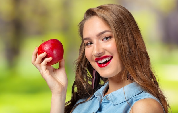 Ritratto della ragazza con la mela rossa isolata