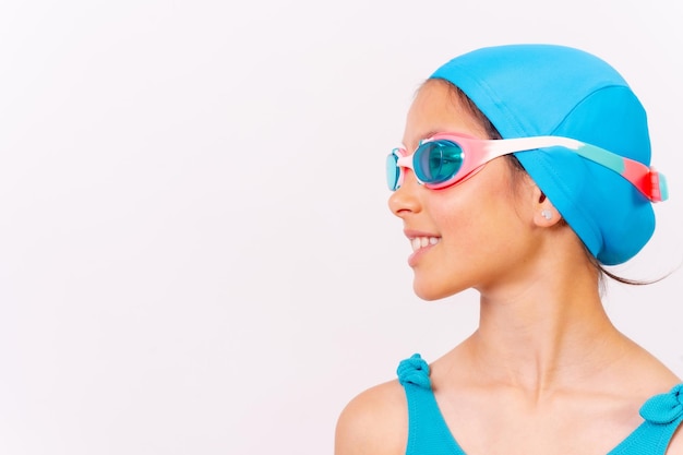Portrait of girl with swimsuit and diving goggles for swimming lessons in the pool in summer white background with copy space