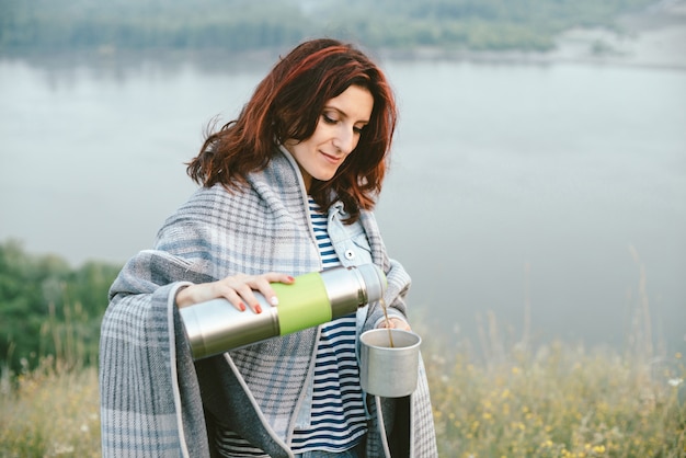 Portrait of girl with thermos and mug