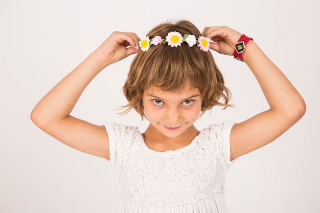 Foto ritratto di una ragazza con una tiara su uno sfondo bianco