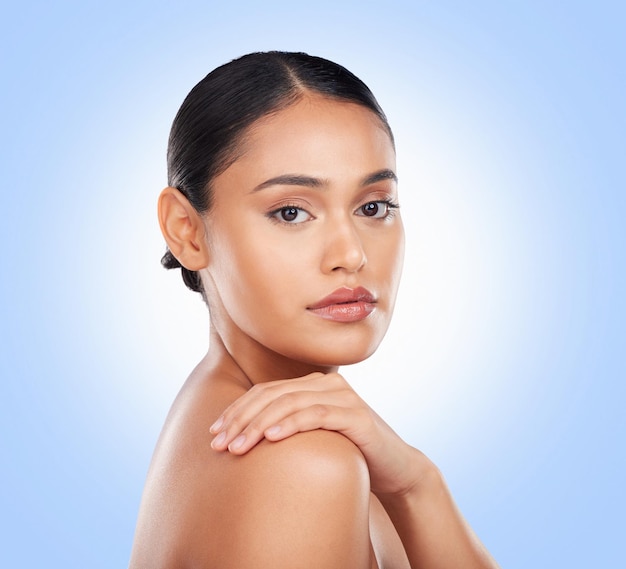 Photo portrait glow and a woman with skincare on a blue background for wellness beauty and health moisture natural and a girl or model touching skin for cosmetics dermatology or grooming on a backdrop