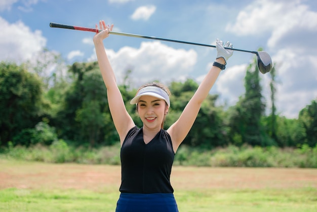 Portrait of golfer asian woman holding golf wood at the country clubHappy woman concept