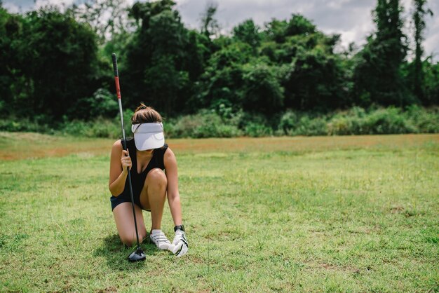 Photo portrait of golfer asian woman holding golf wood at the country clubhappy woman conceptput golf on pin