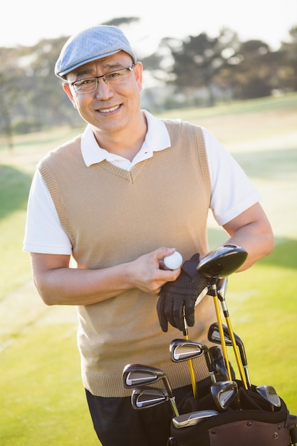 Portrait of golfer posing with his golf equipments