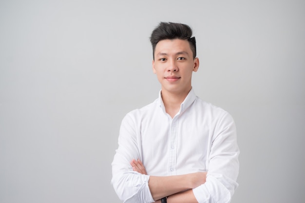 Portrait of good looking asian man over gray background.