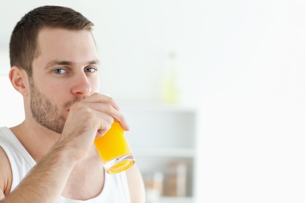 portrait of a good looking man drinking orange juice