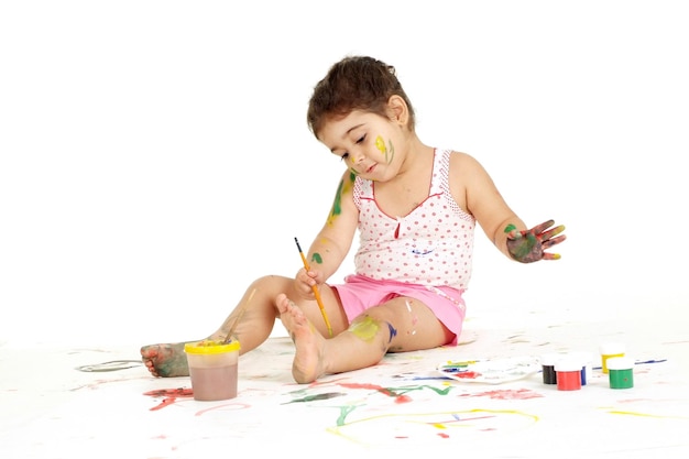 Portrait of good young girl draws painting while sitting on the floor