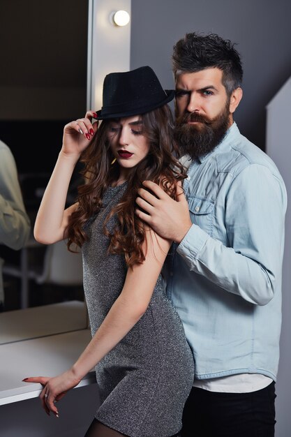 Portrait of gorgeous brunette-haired fashion posing over salon background together