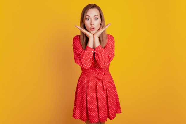 Portrait of gorgeous flirty woman send air kiss in fancy short dress on yellow wall