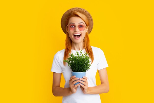 Portrait of gorgeous girl holds pots with exotic sprout Beautiful lady in gardening outfit smiling