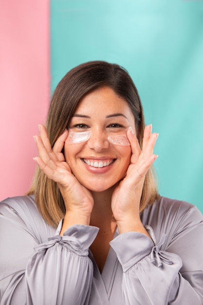 Ritratto di una donna splendida che si applica una crema idratante sul viso