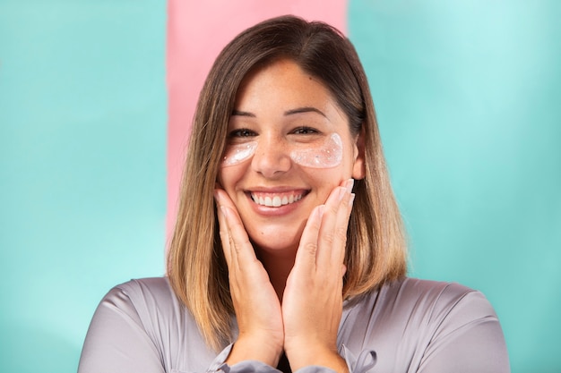 Photo portrait of a gorgeous woman applying moisturizer on her face