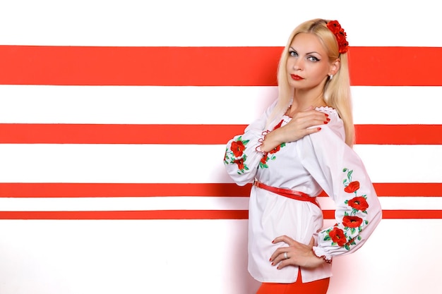 Portrait of gorgeous woman in traditional ukrainian style on a white and red background copyspace hi