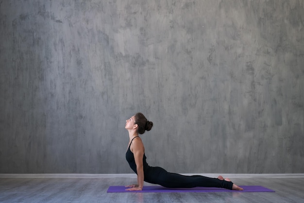 Portrait gorgeous young woman practicing yoga indoors Beautiful little girl