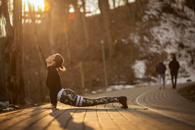 Photo portrait of gorgeous young woman practicing yoga outdoor beautiful girl practice cobra asana