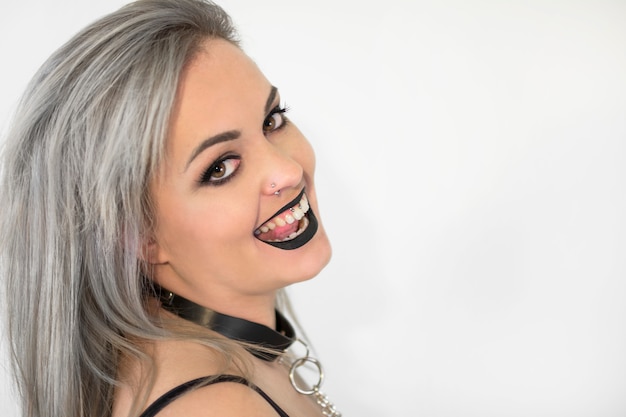 Portrait of gothic woman with smokey makeup, smiling.