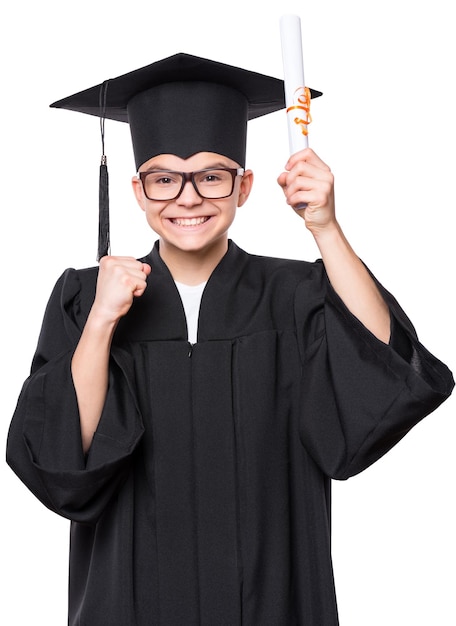 Портрет выпускника-подростка в черном выпускном платье с шляпой и очками, держащего диплом, изолированный на белом фоне.