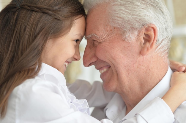 Portrait of a grandfather and granddaughter having fun