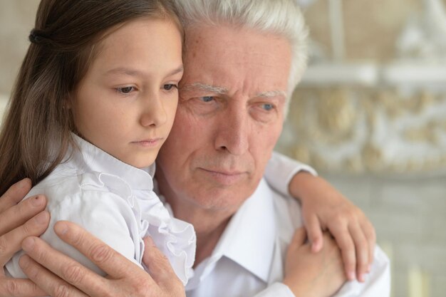 Portrait of grandfather and granddaughter thinking about something