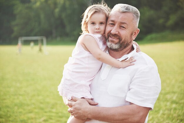 Portrait of grandfather with granddaughter, relaxing together in the park